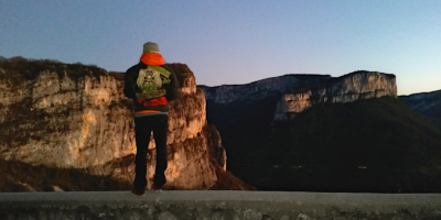 a person looking at rock walls in a valley in the evening sun